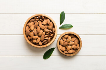 Fresh healthy Almond in bowl on colored table background. Top view