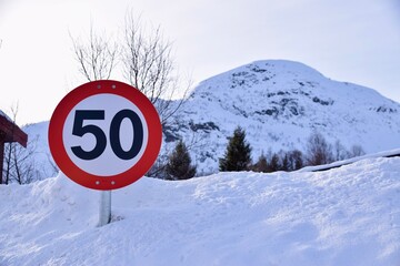 50 kph speed limit sign, Hovden, Norway. Sign against snowy hilly background. Feb 2023. 