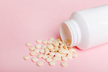 different drugs and health supplement pills poured from a medicine bottle health care and medical top view on colored background