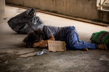 Homeless asking for charity and message on cardboard homeless concept