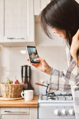 Young beautiful Asian woman using smartphone taking digital picture on screen of healthy food - 576633630