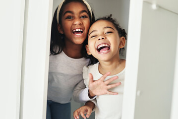 Girl children, door and surprise game with bonding, smile and playful in family home with sisters. African female kids, happy and holiday with love, comic time and funny joke for scare in bedroom