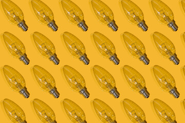 Yellow background. Electric light bulbs pattern. An old glass electric light bulb with a tungsten...