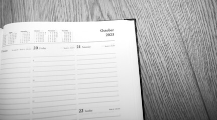 New 2023 year planner agenda with October 2023 empty month - wooden table background black and white background