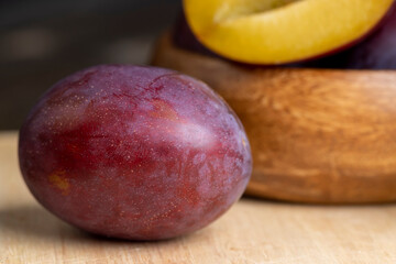 Ripe plums of dark color on the table