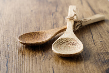 Empty bamboo spoons closeup on wooden board. Kitchenware on wooden table.