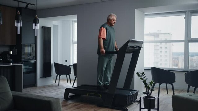 Senior Man Walking On Treadmill In Home, Keeping Fit And Saving Health Of Joints, Healthy Lifestyle