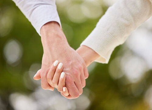Couple holding hands in park for love, date and marriage commitment together in summer garden. Closeup hand of man, woman and walking in nature, loyalty and care for partner, trust or support outdoor