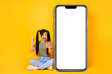 Photo of overjoyed yelling young female excited to see huge sales in her favorite shop isolated on yellow color background