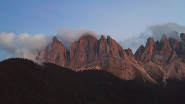 Side moving of camera along the Dolomites of Odle or Geisler group at sunset.