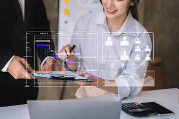 Business team hand Project manager working and update tasks and Gantt chart scheduling virtual diagram.with tablet and laptop in office.