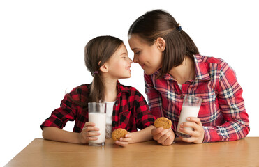 Happy mother and her daughter smiling while drinking milk and eating