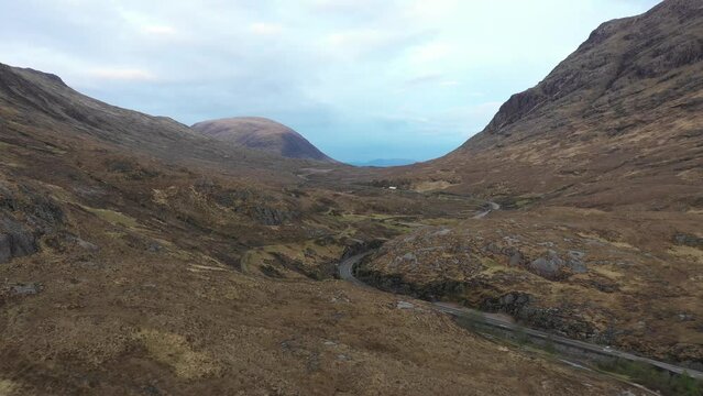 Aerial view of a valley in the Highlands with a road that winds through the mountains