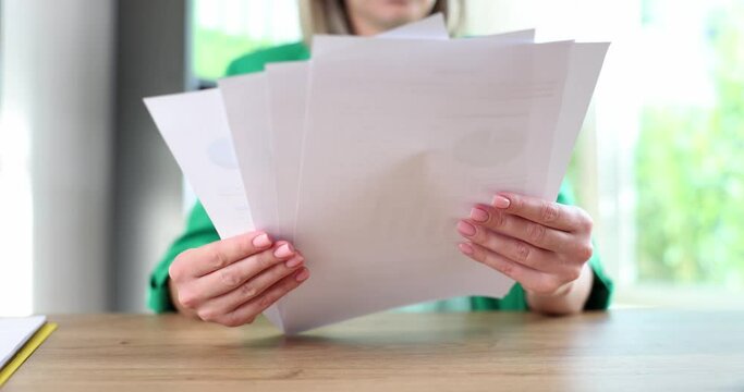 Businesswoman holds business documents over desk concept