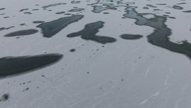 Dolly Looking down at dark spots and patterns on frozen lake
