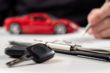 Man signing car insurance document or lease paper. Writing signature on contract or agreement.