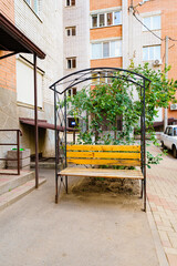 yellow bench at the entrance of a multi-storey apartment building. 