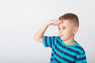 handsome boy looks angry. The child is offended, threatens, shows a fist. Angry, resentful, aggressive child. Portrait on white studio background. Children's human emotions concept.