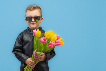 Little boy with bouquet of tulips greeting with Mother's day. Holiday concept. Isolated on blue...