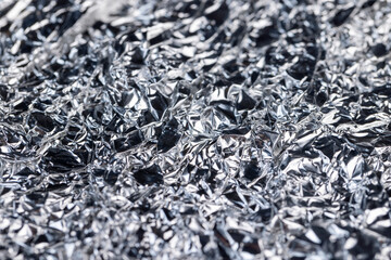 crumpled thin aluminum foil reflecting light