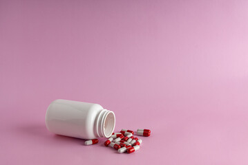 A jar for medicine on a pink background.