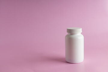 A jar for medicine on a pink background.