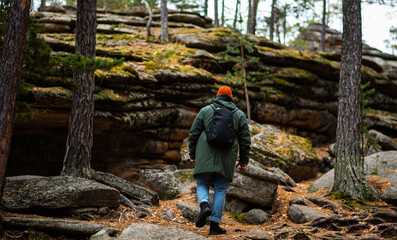 A tourist enjoys the beautiful scenery in northern Finland. Panorama of the autumn pine forest with formation rocks and faults. Northern nature. Nature of Finland autumn. Tourism northern landscape.