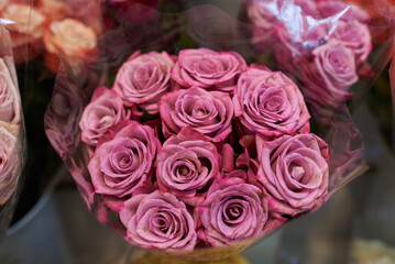 Beautiful bouquets of pink roses in a flower shop. A bright mix of flowers. Handsome fresh bouquets. Flowers delivery. Floral shop. Selective focus.