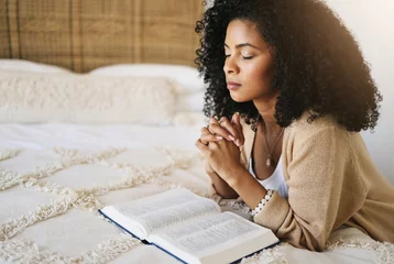 Fotobehang Bible, prayer and black woman praying on bed in bedroom home for hope, help or spiritual faith. God, christian and female worship Jesus or Holy Spirit for forgiveness, compassion or grace in house. © Allistair F/peopleimages.com