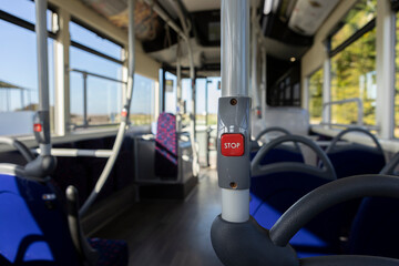 Fototapeta premium close up of a stop button inside a public transport vehicle, request to stop, background blur, selective focus