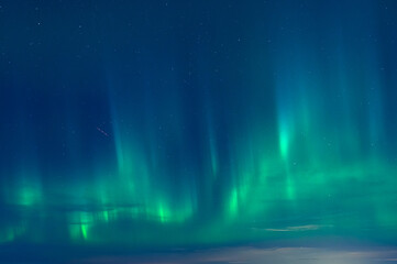 Green Aurora borealis or polar lights on night blue sky