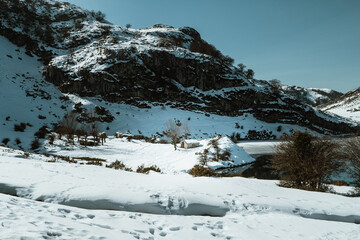 Pequeña casa en medio de un paisaje montañoso nevado en Asturias