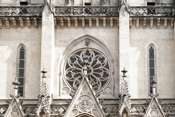Ornate detail of the frontage of St Wenceslas Cathedral, Olomouc, Czech Republic, a white stone gothic cathedral with intricate stonework and carving, round inlaid window and 2 slim tall windows - obrazy, fototapety, plakaty