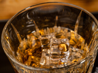 A glass of cognac with ice cubes. A glass of whiskey or bourbon with ice. Close-up.