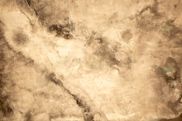 Brown background from decorative plaster with abstract spots. Unusual beige wall texture with beautiful patterns, creative surface background. Front covering for facing of buildings.