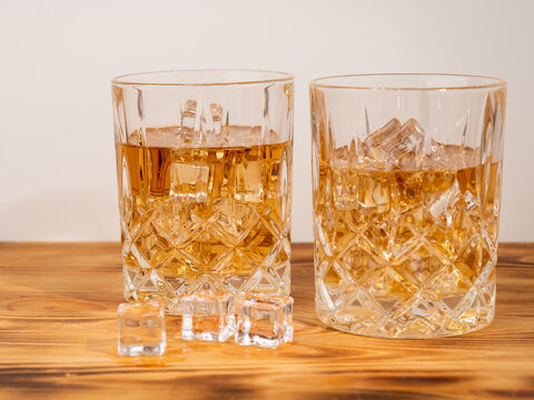 A glass of cognac with ice cubes. A glass of whiskey or bourbon with ice. Close-up.
