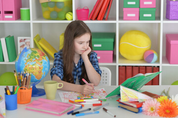 cute girl doing home work at desk