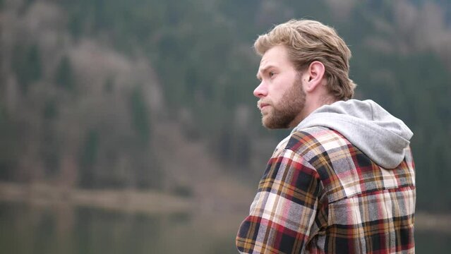 a thoughtful looking man swings his gaze to the left while running his hand through his blond wavy hair. an exhausted gasp ends this video