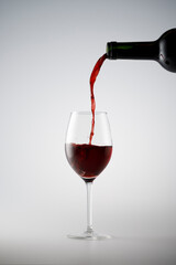 Fototapeta na wymiar Red wine pouring in a wine glass