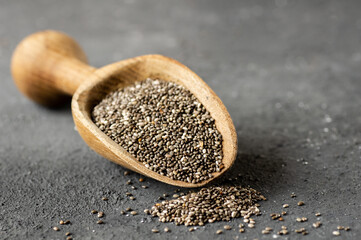 Chia seeds ( Salvia Hispanica ) in wooden shovel or spoon on rustic background. Cereal healthy food 