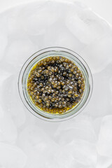 Premium caviar black in glass jar and ice cube
