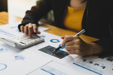 Financial accountant working on auditing and budget analysis on business reports using calculator...