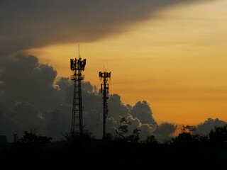 Silhouette view of cellphone antenna under twilight sky.