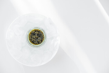 Premium caviar black in glass jar and ice cube