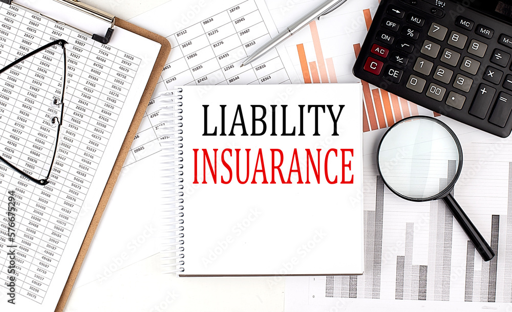 Poster liability insurance text on notebook with clipboard and calculator on a chart background