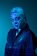 Virtual reality. Portrait of young blonde girl with neon stripes on face posing over dark...