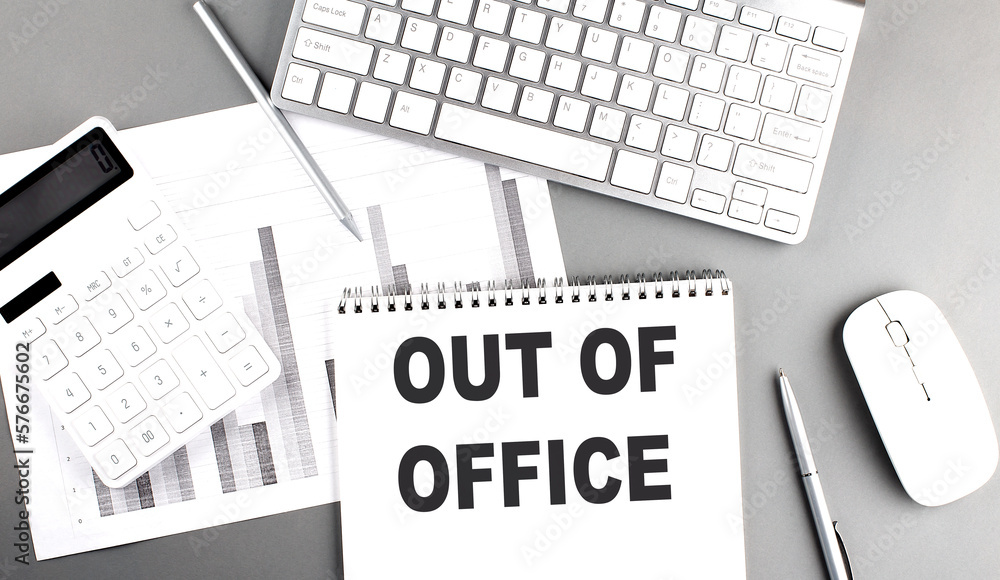 Poster out of office text written on notebook on grey background with chart and keyboard, business concept
