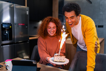 A red-haired girl is surprised by a cake that her boyfriend brought her as a birthday surprise. She is very happy and excited