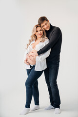 a blonde pregnant woman with a man in black and white clothes hugging