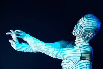 Virtual reality. Portrait of young blonde girl with neon stripes on face posing over dark...